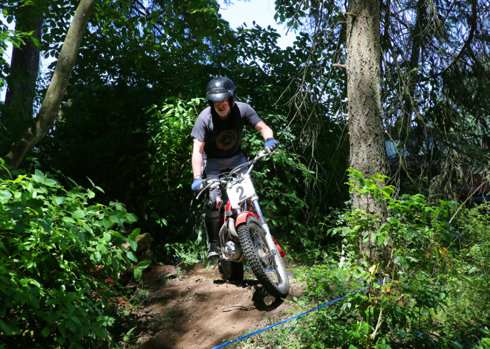 A man riding a motorcycle through a course in the forest in Tacoma, WA.