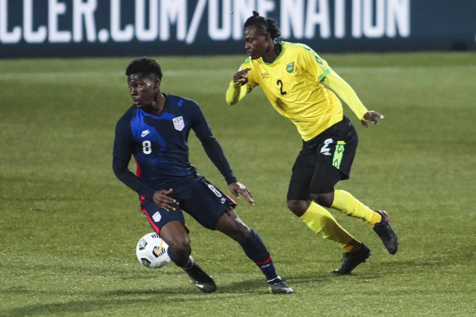 USA's Yunus Musah, left, duels for the ball with Jamaica's Chavany Willis during the international friendly soccer match between USA and Jamaica at SC Wiener Neustadt stadium in Wiener Neustadt, Austria, Thursday, March 25, 2021. (AP Photo/Ronald Zak)