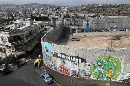 A general view shows graffiti on the controversial Israeli barrier, opposite Banksy's Walled Off Hotel (L), in the West Bank city of Bethlehem October 28, 2017. Picture taken October 28, 2017. REUTERS/Ammar Awad NO RESALES. NO ARCHIVES.