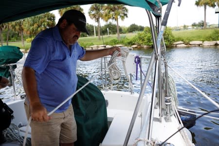 Ned Keahey, who lives in a sailboat with his wife Lisa and plans to stay aboard during Hurricane Dorian, secures his sailboat at a marina in Titusville