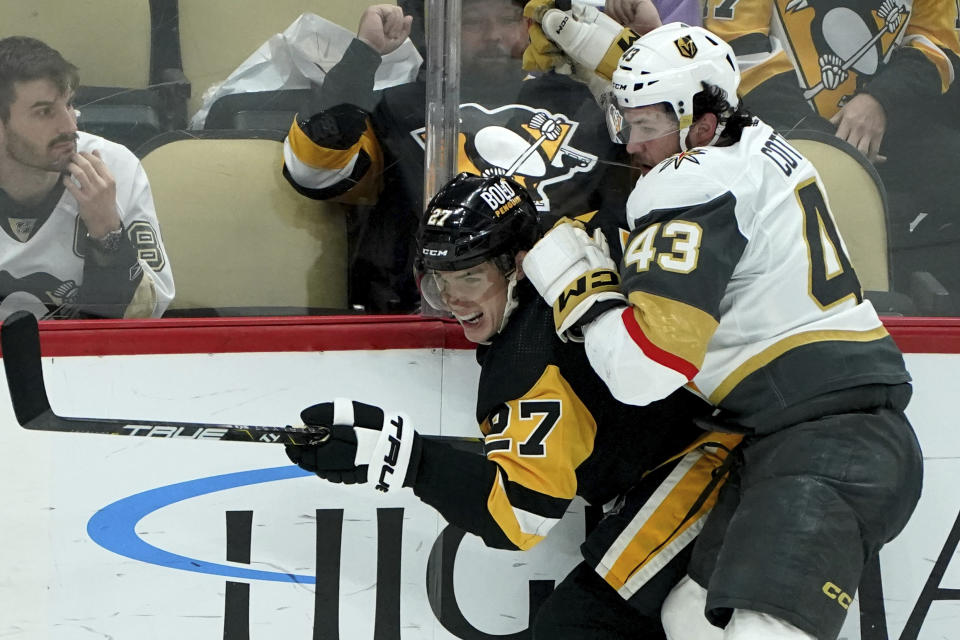Vegas Golden Knights' Paul Cotter (43) checks Pittsburgh Penguins' Ryan Graves into the boards during the third period of an NHL hockey game, Sunday, Nov. 19, 2023, in Pittsburgh. (AP Photo/Matt Freed)
