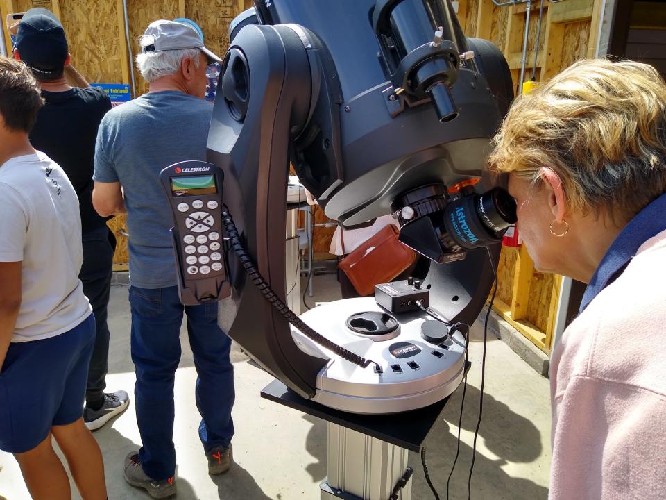 Visitors take turns peering through telescopes at the Fairlawn Rotary Observatory in Bath Nature Preserve during the solar eclipse Monday.