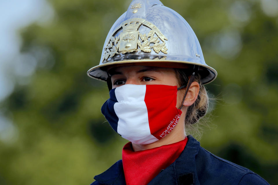 FILE - In this July 14, 2020, file photo, a firefighter wears a face mask with the colors of the French flag, prior to the Bastille Day parade on the Champs-Élysées avenue in Paris. Masks made of cotton and other washable materials have become a big seller as face coverings have emerged as one of the most effective ways to prevent further spread of the coronavirus. (AP Photo/Christophe Ena, Pool)