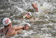 <p>China's Xin Xin (L) competes in the women's 10km marathon swimming event as a competitor takes refreshment at a feed station during the Tokyo 2020 Olympic Games at the Odaiba Marine Park in Tokyo on August 4, 2021. (Photo by Oli SCARFF / AFP)</p> 