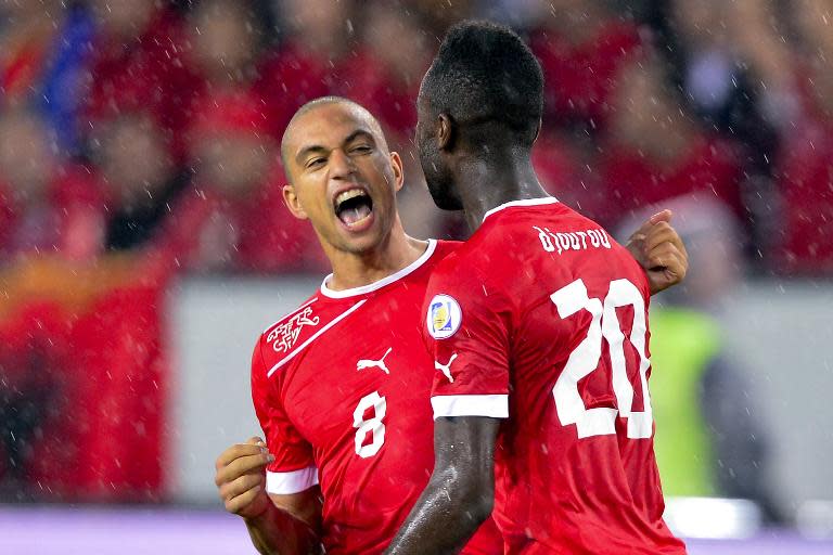 Switzerland's Goekhan Inler (L) celebrates his team's second goal during their 2014 World Cup qualifying football match against Albania on September 11, 2012 in Lucerne