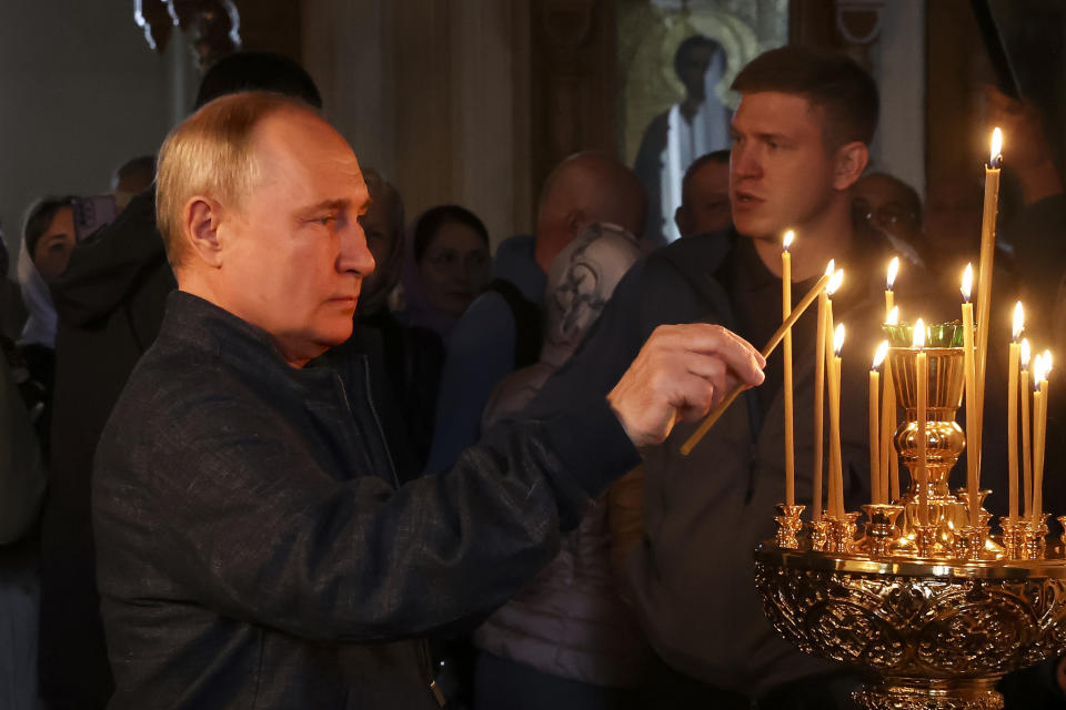 FILE - Russian President Vladimir Putin lights a candle as he visits the Valaam Monastery of the Transfiguration of the Savior, on Valaam island in Ladoga Lake, Republic of Karelia, Russia, Monday, July 24, 2023. During his more than two decades in power, Putin has massively boosted the Russian Orthodox Church's standing, increasing its prestige, wealth and power in society after decades of oppression or indifference under Soviet leaders. In turn, its leaders, like Patriarch Kirill, have supported his initiatives. (Alexander Demianchuk, Sputnik, Kremlin Pool Photo via AP, File)