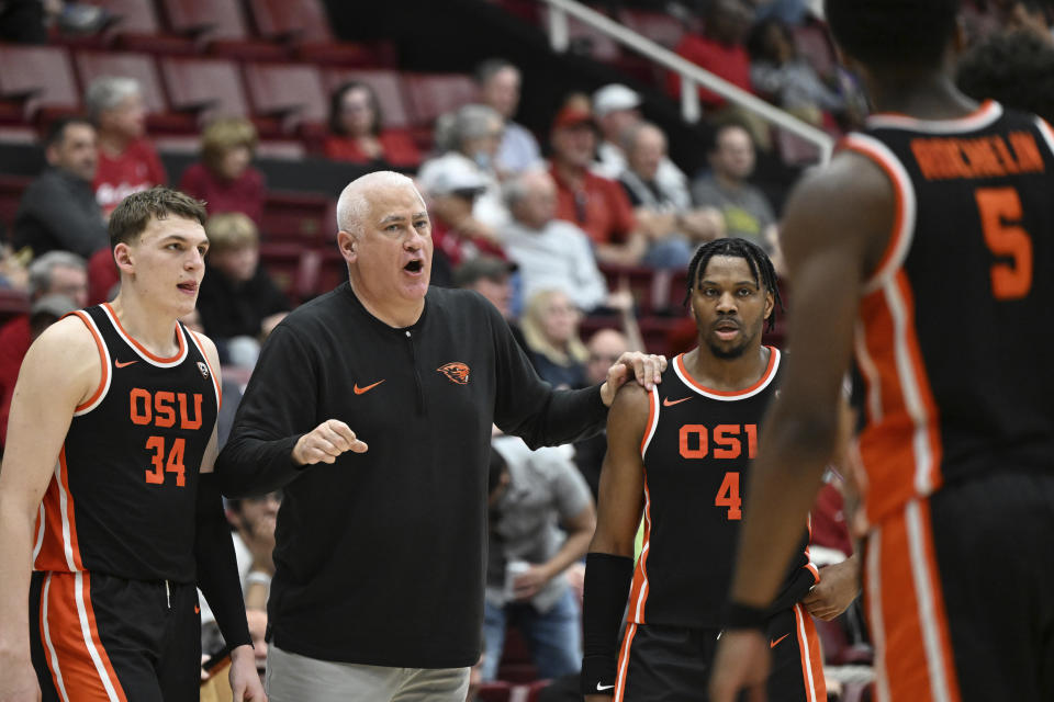 Oregon State forward Tyler Bilodeau (34), guard Dexter Akanno (4) and guard Justin Rochelin (5) listen to head coach Wayne Tinkle, second from left, during the second half of an NCAA college basketball game against Stanford, Saturday, Feb. 24, 2024, in Stanford, Calif. (AP Photo/Nic Coury)