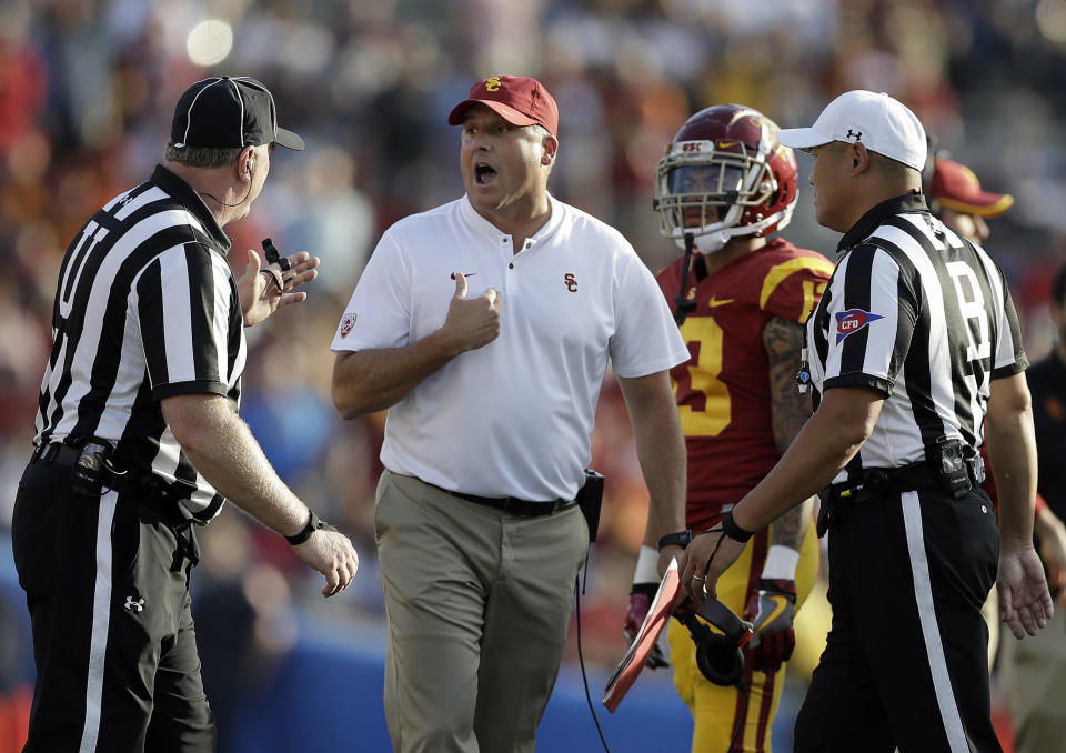 Southern California head coach Clay Helton, center, argues a call with a referee during the second half of an NCAA college football game against UCLA, Saturday, Nov. 17, 2018, in Pasadena, Calif. (AP Photo/Marcio Jose Sanchez)