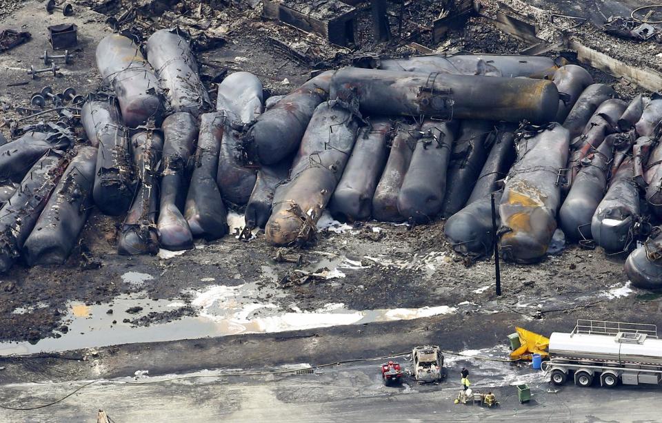 RNPS - PICTURES OF THE YEAR 2013 - A firefighter stands near the wreckage of a train derailment and explosion, in Lac-Megantic July 8, 2013. The driverless, runaway fuel train that exploded in a deadly ball of flames in the centre of the small Quebec town started rumbling down an empty track just minutes after a fire crew had extinguished a blaze in one of its parked locomotives, an eyewitness said. REUTERS/Mathieu Belanger (CANADA - Tags: DISASTER TRANSPORT TPX)