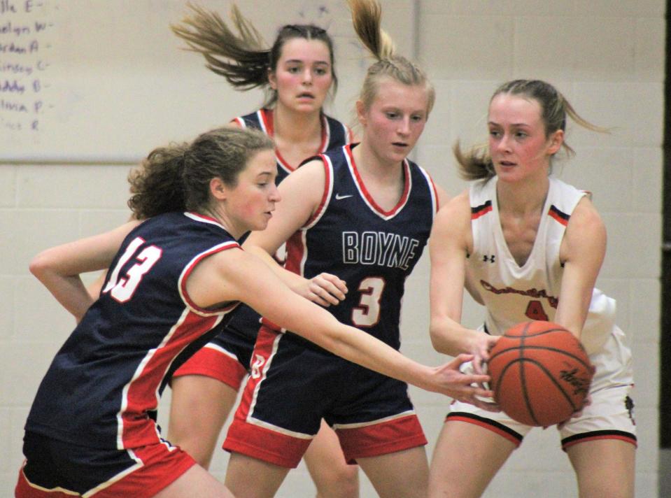 Boyne City's Delaney Little (13) and Mackensy Wilson (3) trap a Cheboygan player with the ball during Tuesday's season opener, which Boyne City earned a comeback win in.