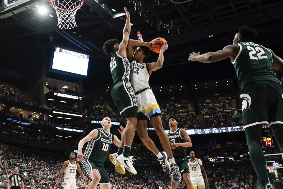 Marquette forward Oso Ighodaro (13) drives on Michigan State forward Malik Hall (25) in the second half of a second-round men's college basketball game in the NCAA Tournament Sunday, March 19, 2023, in Columbus, Ohio. (AP Photo/Paul Sancya)