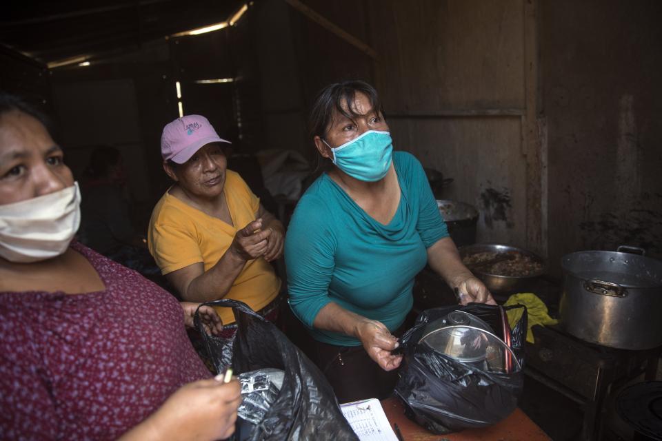 Mujeres sirven el almuerzo a los vecinos en el comedor social "Dios es Amor" en el barrio Nueva Esperanza en medio de la nueva pandemia de coronavirus, en las afueras de Lima, Perú, el martes 22 de septiembre de 2020. (AP Foto/Rodrigo Abd)