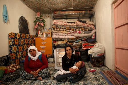 Sevgi Gezici, widow of Engin Gezici, holding her daughter Helin, sits next to her mother-in-law Seviye Gezici (L) at their family house in the southeastern town of Silvan in Diyarbakir province, Turkey, December 7, 2015. REUTERS/Murad Sezer