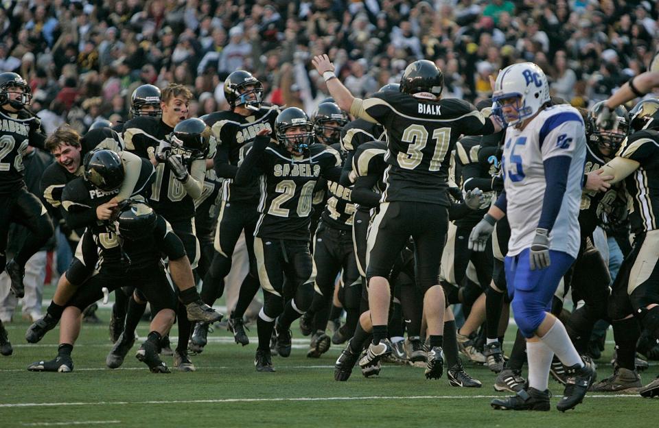 Brookfield Central's Jacob Glickstein walks off the field as the Franklin bench erupts in victory in overtime of their WIAA Division 2 state football championship game at Camp Randall Stadium in Madison, Friday, Nov, 17, 2006.