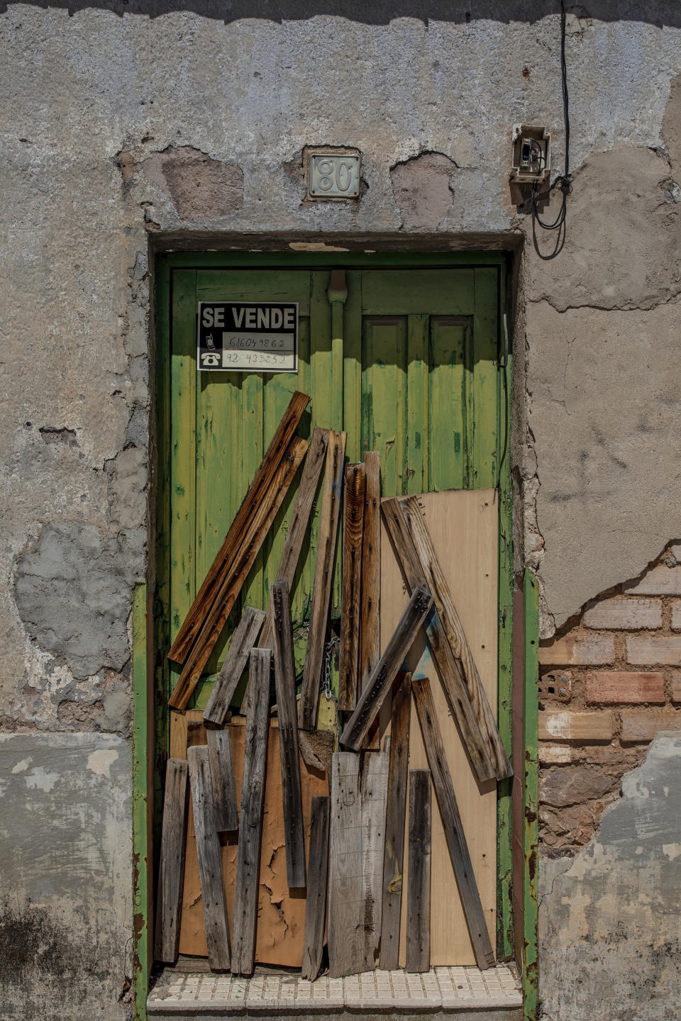 In this April 10, 2019, photo, a sealed door of a house for sale in Puertollano, near Ciudad Real, central Spain. Spanish politicians are swapping campaign buses for tractors, buddying up with hunters and inspecting home-grown tomatoes in Spain’s often-neglected rural regions as they hunt for votes in Sunday’s general election, one of the country’s most polarized votes in decades.(AP Photo/Bernat Armangue)