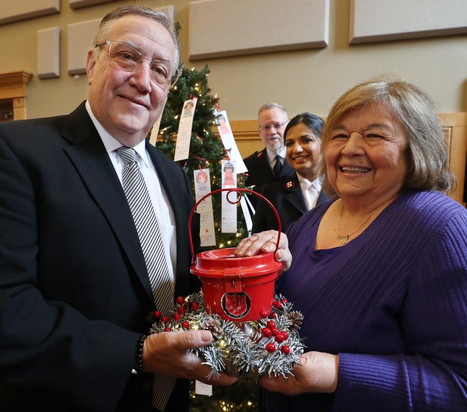 Community Medal Award recipients Ray Horner and Joyce Lagios, both of Rubber City Radio Group, hold a miniature kettle Thursday as they take a portrait with Salvation Army Maj. Robert Watson and Capt. Anita Albert-Watson at St. George Fellowship Hall in Copley. The late Mark Biviano received a posthumous award.