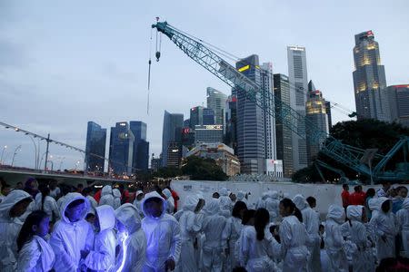 Children wearing costumes that light up with LED lights prepare to march into a National Day Golden Jubilee parade rehearsal at the Padang in Singapore July 25, 2015. The city-state's 50th independence day falls on August 9. REUTERS/Edgar Su