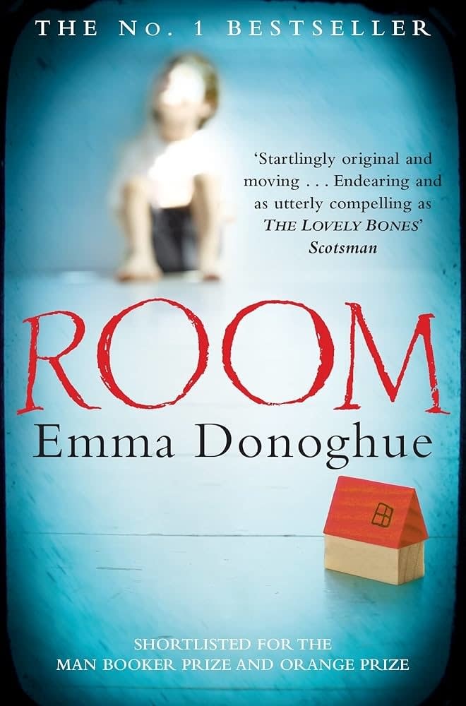 Book cover of "ROOM" by Emma Donoghue with a blurred figure behind a red cardboard house