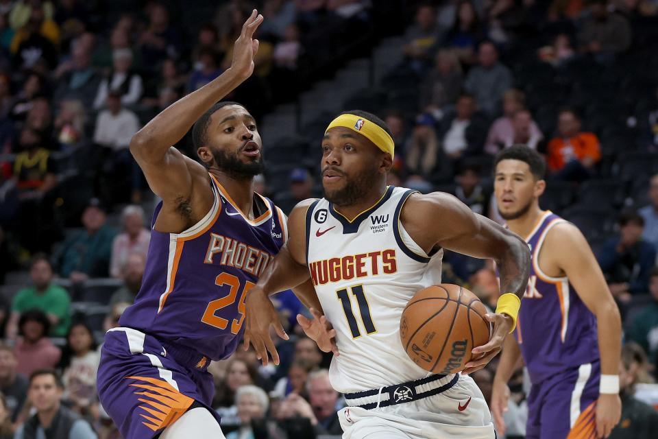 Bruce Brown #11of the Denver Nuggets drives against Mikal Bridges #25 of the Phoenix Sun in the first quarter during a preseason game at Ball Arena on October 10, 2022, in Denver, Colorado.