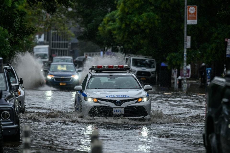 Vehicles make their way through floodwater.