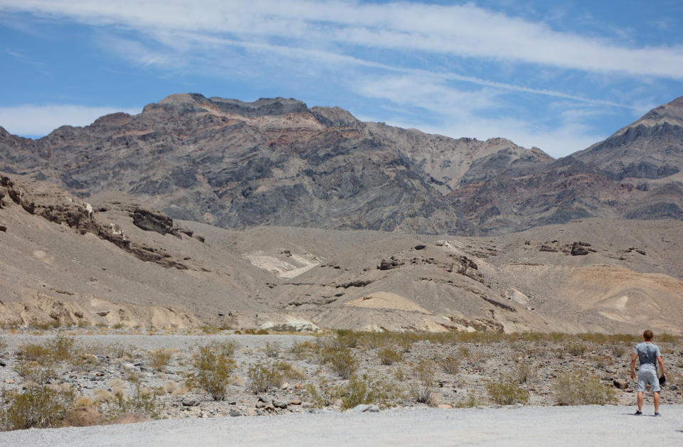 A tourist looks out in the distance during a heat wave in Death Valley National Park in Death Valley, California, on July 16, 2023. Tens of millions of Americans braced for more sweltering temperatures Sunday as brutal conditions threatened to break records due to a relentless heat dome that has baked parts of the country all week. By the afternoon of July 15, 2023, California's famous Death Valley, one of the hottest places on Earth, had reached a sizzling 124F (51C), with Sunday's peak predicted to soar as high as 129F (54C). Even overnight lows there could exceed 100F (38C). (Photo by Ronda Churchill / AFP) (Photo by RONDA CHURCHILL/AFP via Getty Images)