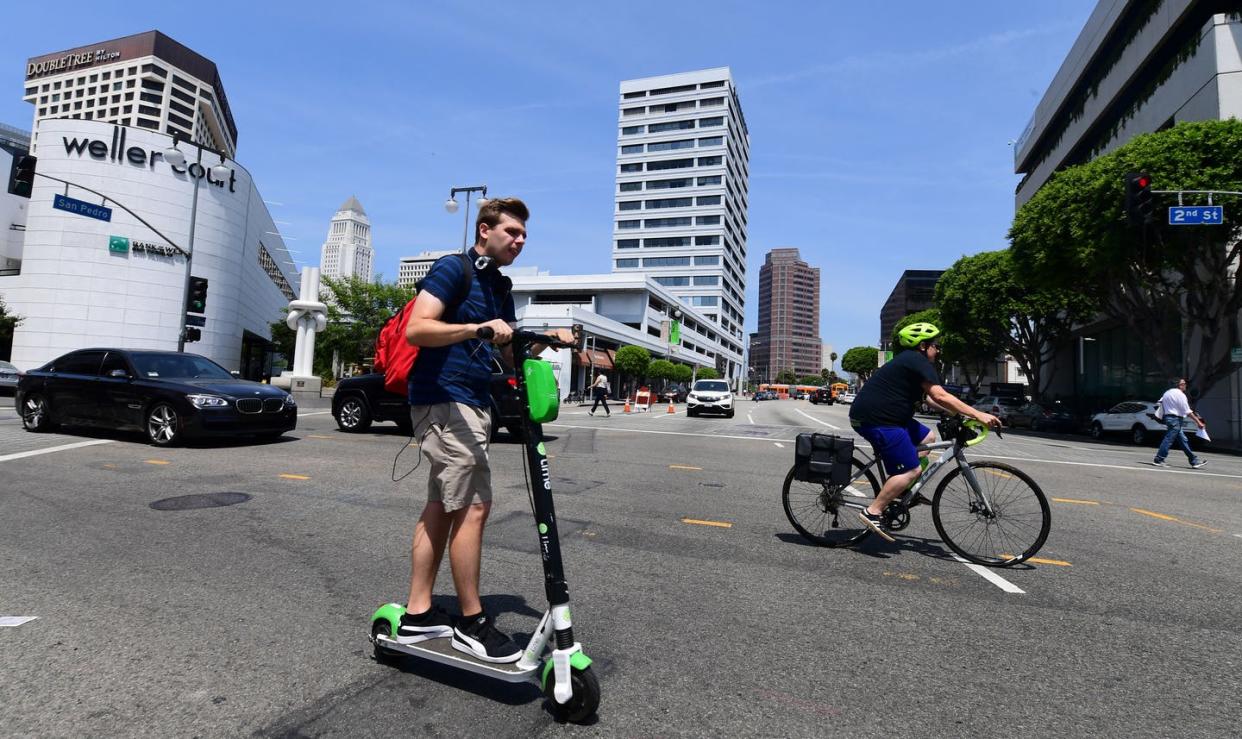 <span class="caption">Electric scooters have become a popular way to get around since their introduction to U.S. cities about three years ago. But fatalities are mounting. </span> <span class="attribution"><a class="link " href="https://www.gettyimages.com/detail/news-photo/commuter-rides-an-e-scooter-across-a-los-angeles-street-on-news-photo/1163246014?adppopup=true" rel="nofollow noopener" target="_blank" data-ylk="slk:Frederic J. Brown/AFP via Getty Images;elm:context_link;itc:0;sec:content-canvas">Frederic J. Brown/AFP via Getty Images</a></span>