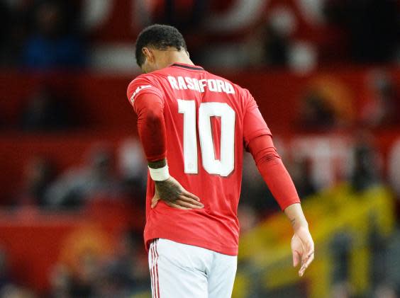 Rashford clutches his back after being risked by Solskjaer (EPA)