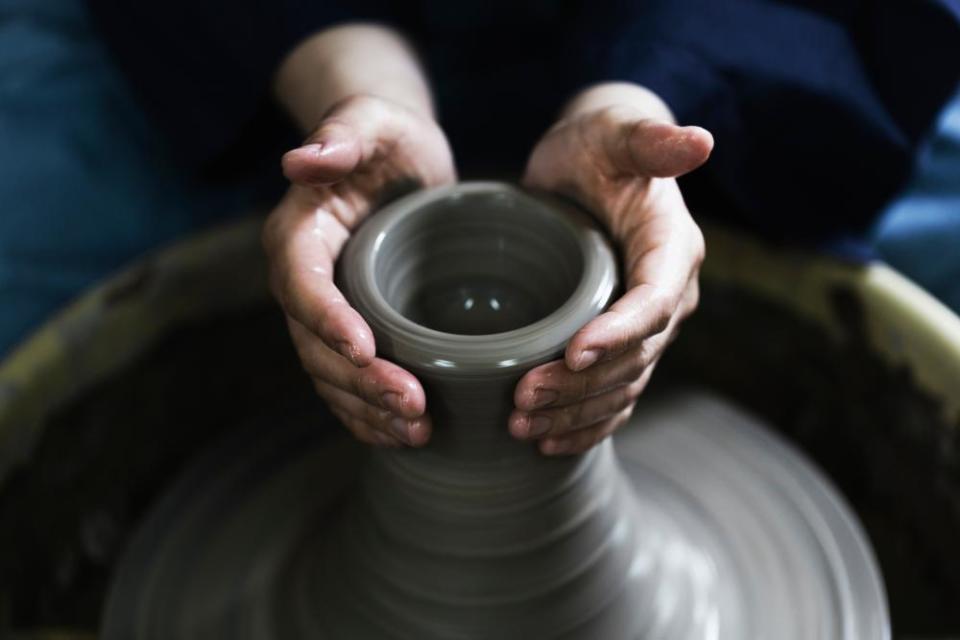 Hands of woman enjoying pottery.