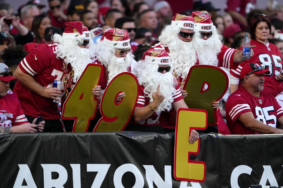 San Francisco 49ers fans in Santa Claus beards spell out 49ers during the first half of an NFL football game against the Arizona Cardinals, Sunday, Dec. 17, 2023, in Glendale, Ariz. (AP Photo/Matt York)
