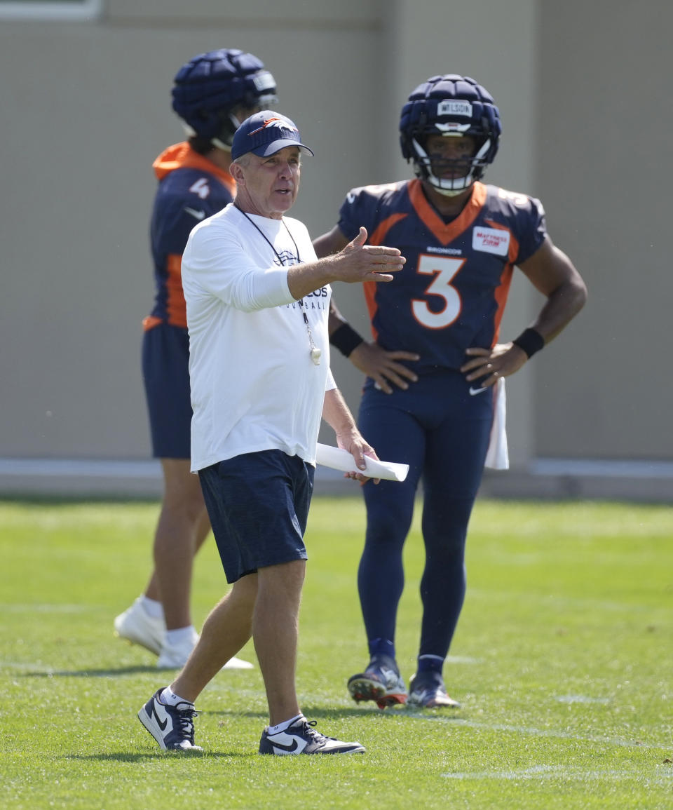 Denver Broncos head coach Sean Payton, front left, directs players as quarterback Russell Wilson (3) looks on during an NFL football training camp at the team's headquarters Monday, Aug. 14, 2023, in Centennial, Colo. (AP Photo/David Zalubowski)