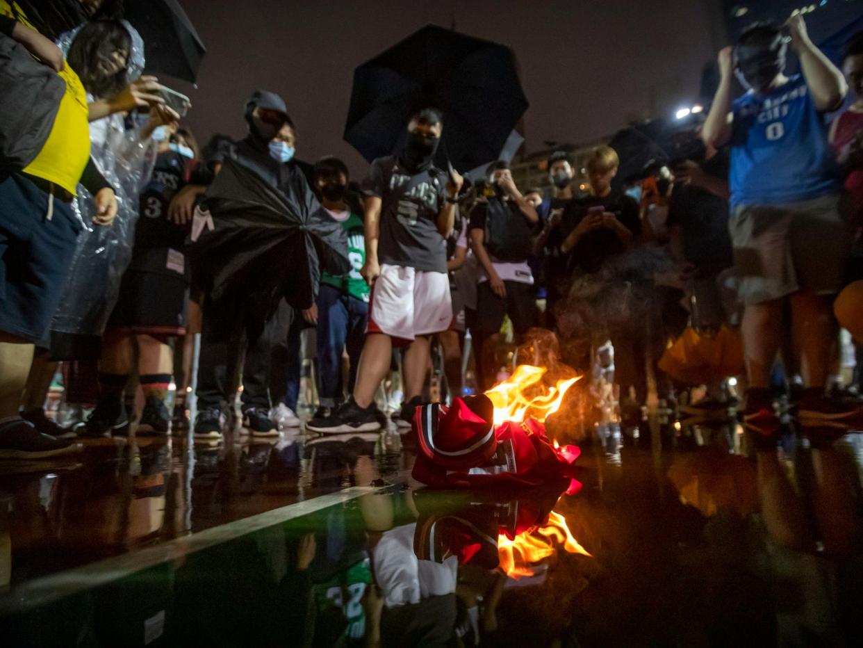 Demonstrators in Hong Kong burn a LeBron James basketball jersey in protest at his comments over free speech: AP