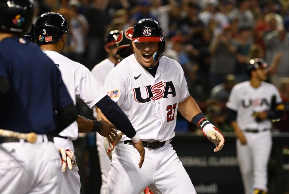 Mike Trout celebrates with teammates after hitting a three-run home run in the first inning against Canada.