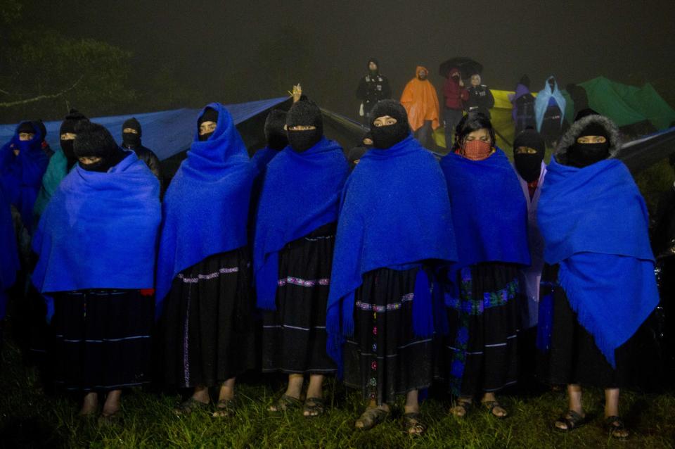 Masked women from the Zapatista National Liberation Army, EZLN, stand at attention during an event marking the 20th anniversary of the Zapatista uprising in the town of Oventic, Chiapas, Mexico, late Tuesday, Dec. 31, 2013. The rebellion stunned Mexico and drew widespread support from leftists across the world. But little has changed in the secretive, closed-off enclaves the Zapatistas have formed over the last two decades in the half-dozen communities they hold. (AP Photo/Eduardo Verdugo)
