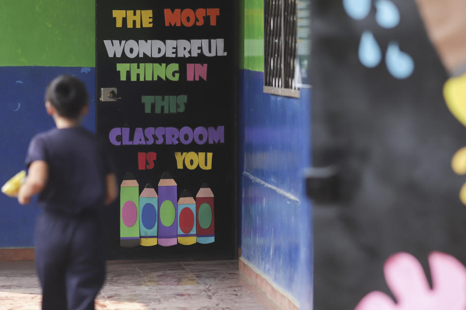 A student walks through a hallway of the Hosanna School, an institution run by the Assemblies of God Church, in an area once controlled by gangs, in Santa Ana, El Salvador, Wednesday, May 3, 2023. (AP Photo/Salvador Melendez)