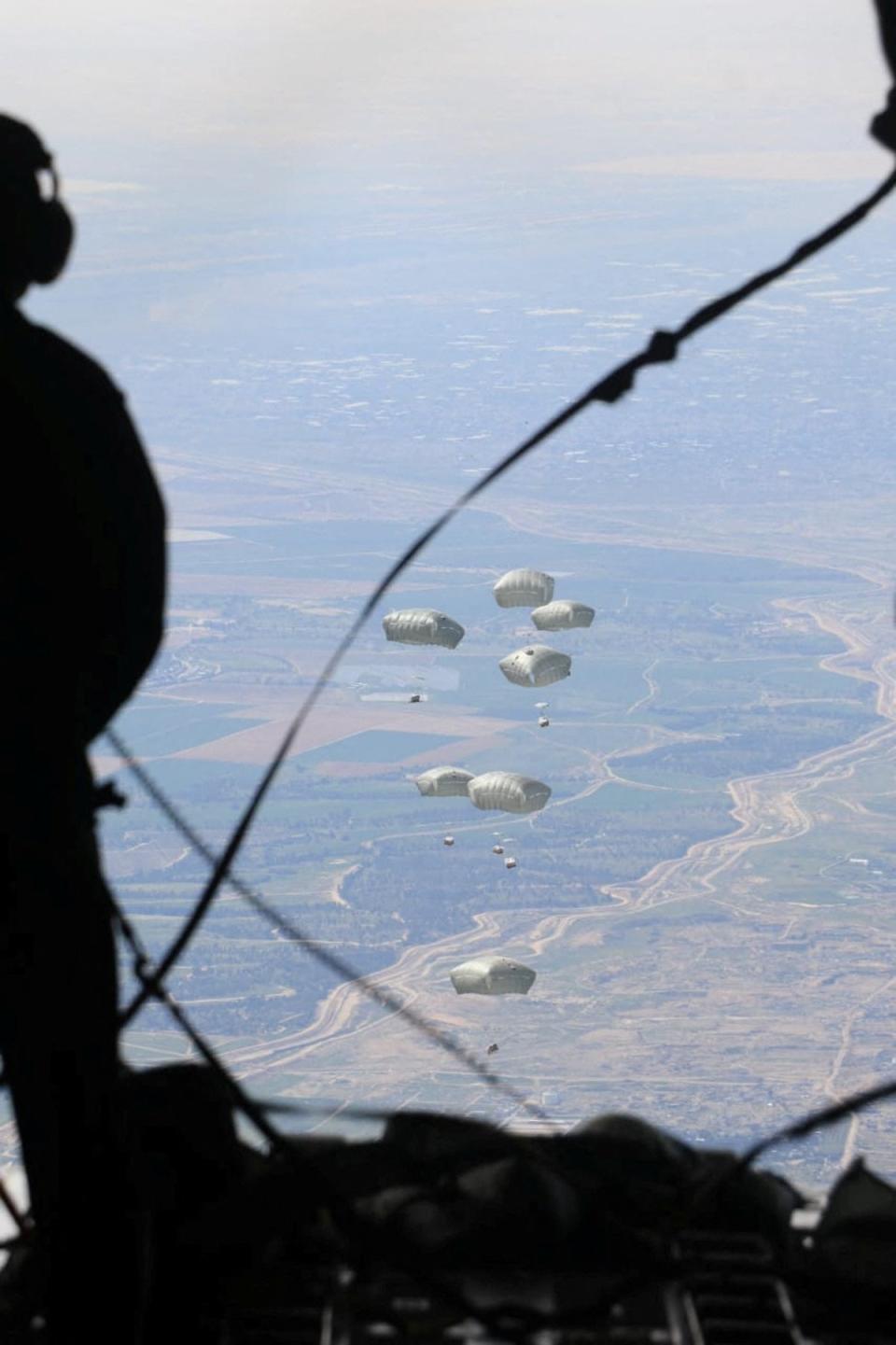 Jordanian armed forces members airdrop aid parcels to several areas in northern Gaza (via REUTERS)