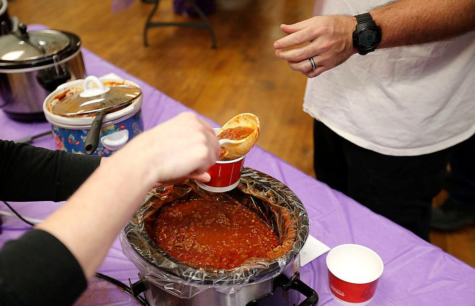 A cup of hot chili is served to a guest at Relay For Life of Ashland County-Mid Ohio's chili cook-off and quarter paddle auction held in Mozelle Hall at the Ashland County Fairgrounds Friday. TOM E. PUSKAR/ASHLAND TIMES-GAZETTE