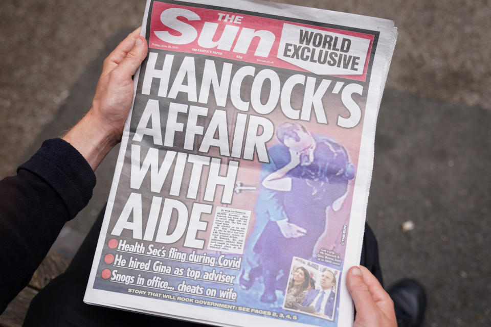 A person reads a copy of the Sun newspaper in Westminster, London, with the story and pictures of Health Secretary Matt Hancock appearing to kiss his adviser Gina Coladangelo, who the newspaper said was hired by Mr Hancock last year. Picture date: Friday June 25, 2021. (Photo by Kirsty O&#39;Connor/PA Images via Getty Images)