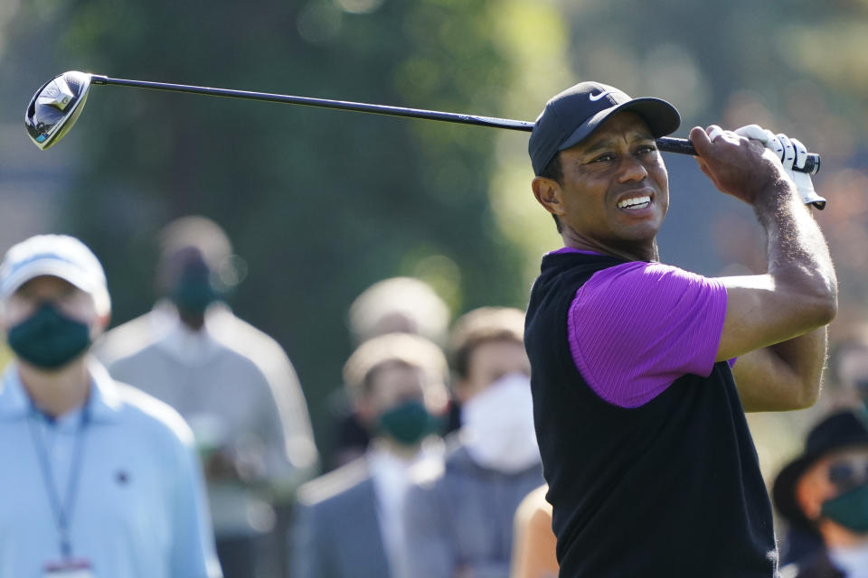 Tiger Woods follows his ball after teeing off at the first hole during the third round of the Masters golf tournament Saturday, Nov. 14, 2020, in Augusta, Ga. (AP Photo/Charlie Riedel)