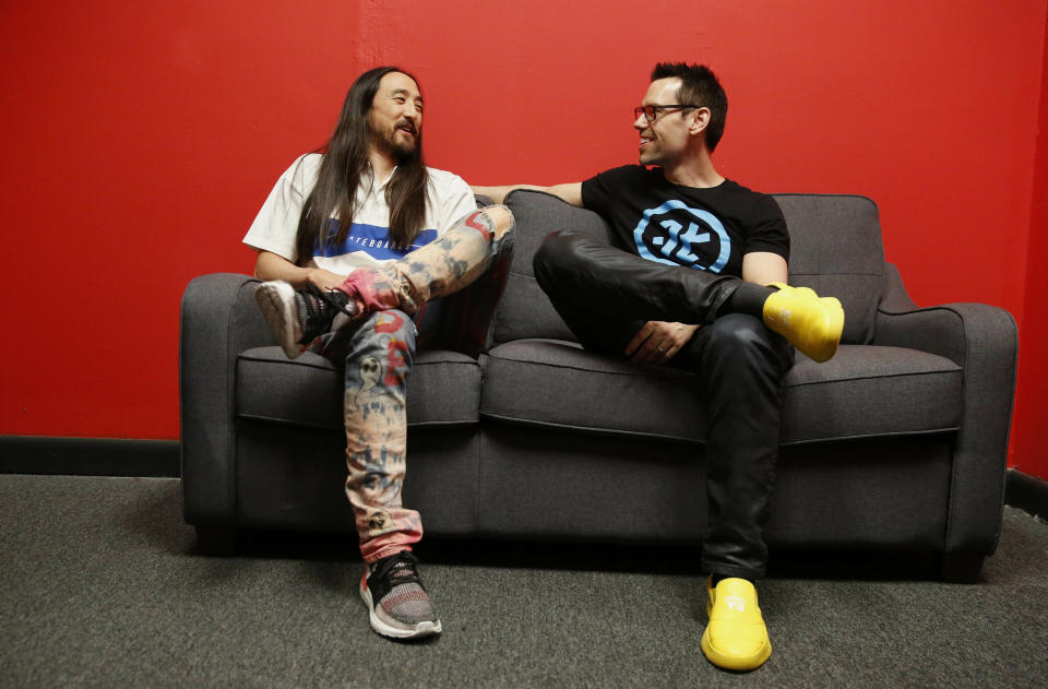 Steve Aoki, left, and Tom Bilyeu, right, sit for a portrait during a comic book signing of his new comic book series "Neon Future" at Multiverse Corps. Comics on Thursday, May 2, 2019, in Miami. (AP Photo/Brynn Anderson)