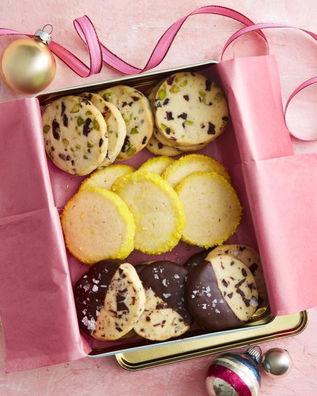 flat lay with christmas cookies on baking pan, christmas wreath, cardboard  box and cookie cuttrers Stock Photo by LightFieldStudios