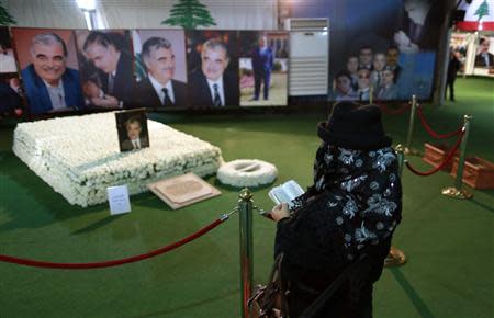 A woman reads the Koran at the grave of assassinated Lebanese former prime minister Rafik al-Hariri in downtown Beirut January 17, 2014. REUTERS/Jamal Saidi