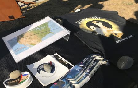 Eclipse sunglasses, T-shirt, map of the moon's shadow during the August 21, 2017 eclipse, and stickers are seen at a table run by Wyoming Stargazing at the outdoor Wednesday market in Jackson, Wyoming, U.S. July 12, 2017. REUTERS/Ann Saphir