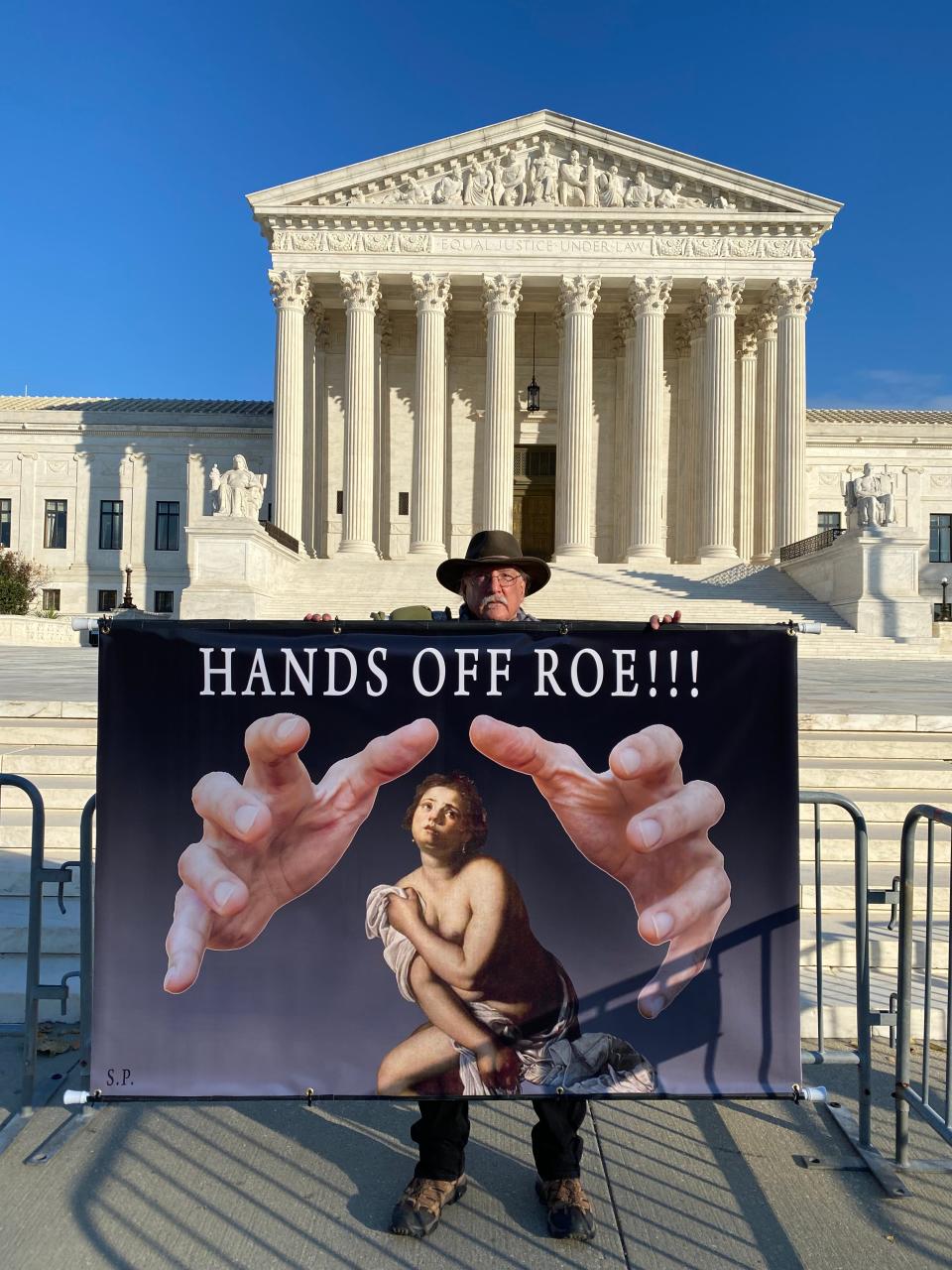 Stephen Parlato, 67, of Boulder, Colo., demonstrates outside the Supreme Court on Nov. 30, 2021, calling barriers to abortion "a war on those who are already warred upon."