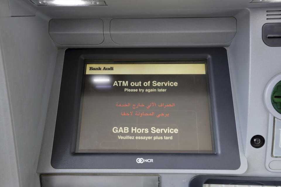 An ATM screen notifies customers that it is out of service, outside a closed bank in Beirut, Lebanon, Tuesday, Nov. 12, 2019. Lebanon's banking association says banks will continue to be closed due to a strike by employees as the country's financial crisis worsens. (AP Photo/Hassan Ammar)