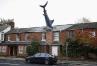 A model of a shark is seen in the roof of a house in Oxford October 26, 2013. The rooftop sculpture is 25 feet (7.6 m) long, made of fibre glass and was erected on the 41st anniversary of the dropping of the atomic bomb on Nagasaki. REUTERS/Eddie Keogh (BRITAIN - Tags: SOCIETY)