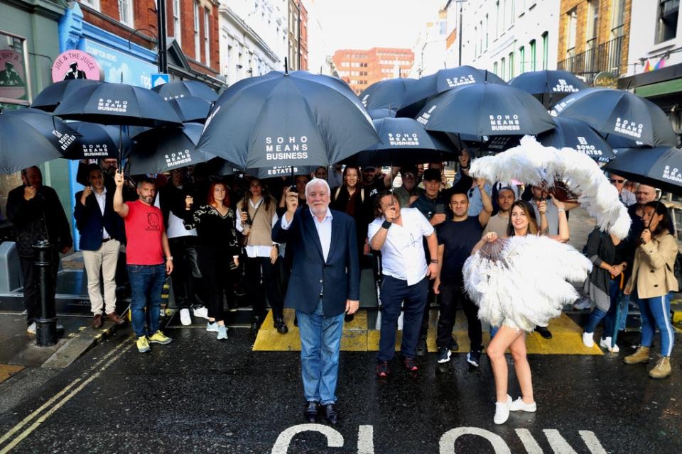 Singin’ in the rain:  John James, centre, is heading the brolly handout, which he hopes will raise awareness   (Press Handout)