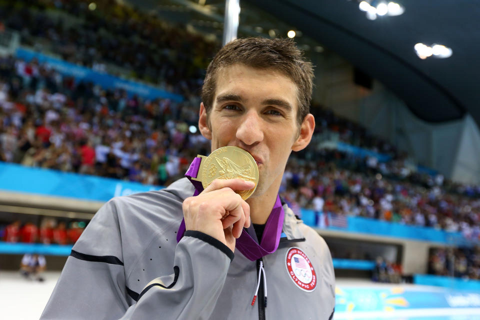 LONDON, ENGLAND - AUGUST 04: Gold medallist Michael Phelps of the United States kisses his medal following the medal ceremony for the Men's 4x100m medley Relay Final on Day 8 of the London 2012 Olympic Games at the Aquatics Centre on August 4, 2012 in London, England. (Photo by Al Bello/Getty Images)