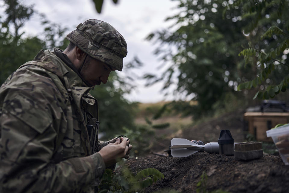 Un soldado de Ucrania carga una bomba en un dron cerca de Bájmut, en la región de Donetsk, Ucrania, el domingo 3 de septiembre de 2023. (AP Foto/Libkos)