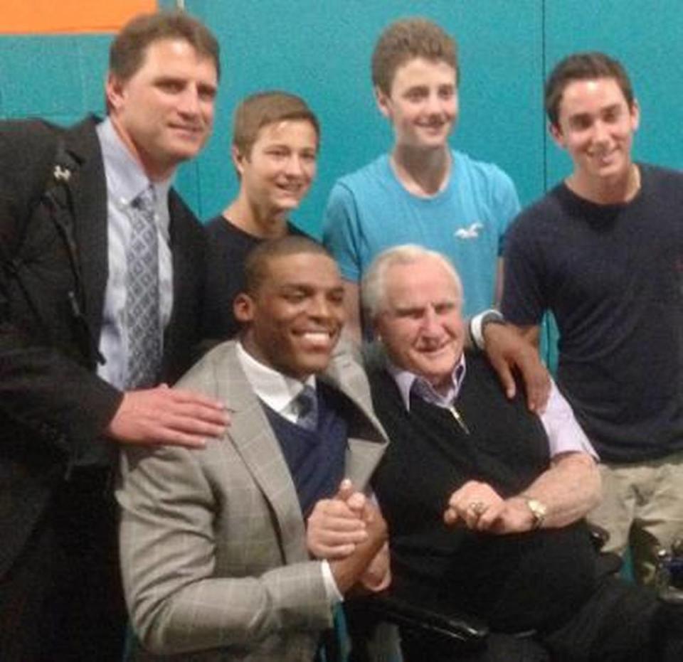 In 2013, after a Carolina Panthers victory over the Miami Dolphins in Florida, Cam Newton (left, seated) and former Dolphins coach Don Shula posed for a photo together. Mike Shula (far left, standing) was the Panthers’ offensive coordinator at the time.