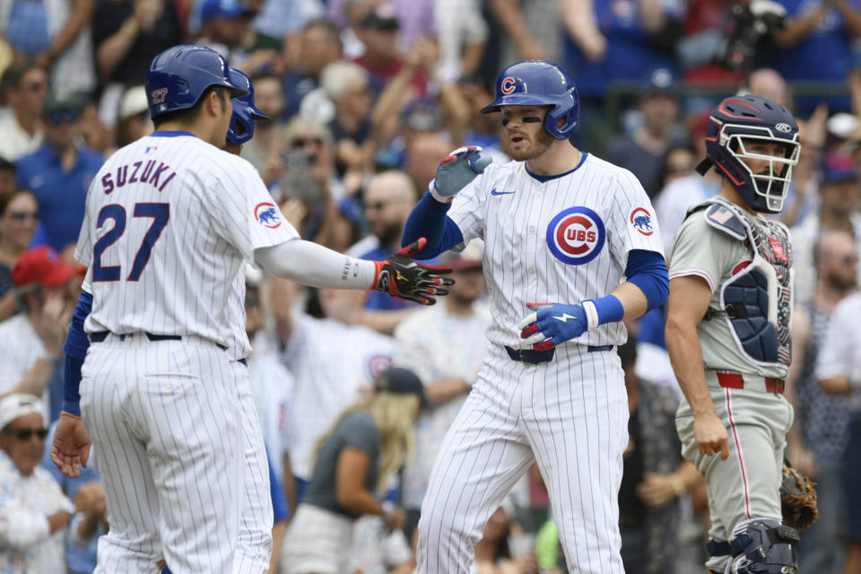 Chicago Cubs' Ian Happ, second from right, celebrates with teammates Seiya Suzuki (27) and Cody Bellinger, back left, at home plate after hitting a three-run home run during the fourth inning of a baseball game against the Philadelphia Phillies, Thursday, July 4, 2024, in Chicago. (AP Photo/Paul Beaty)